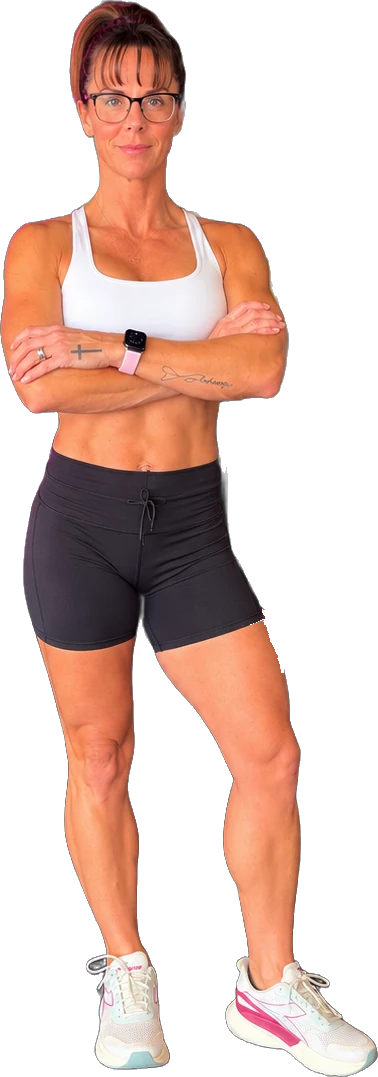 Kelli Anderson standing with arms crossed in a white sports top and black training shorts